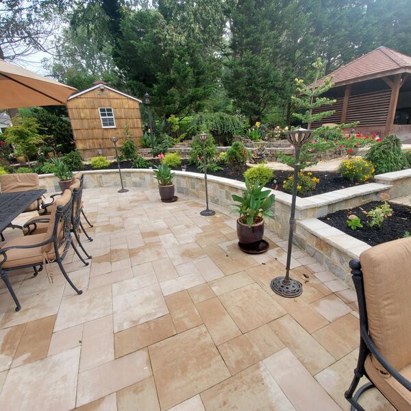 Spacious backyard patio with seating area and retaining walls